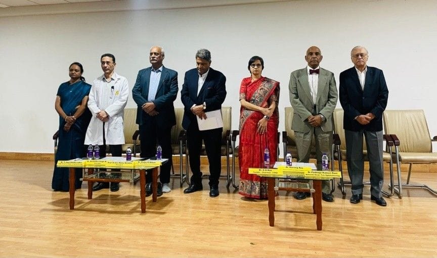 Dr Madhu Mohan and dignitaries standing on stage during formal event