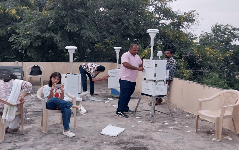 Technicians installing and monitoring air quality sensors on rooftop