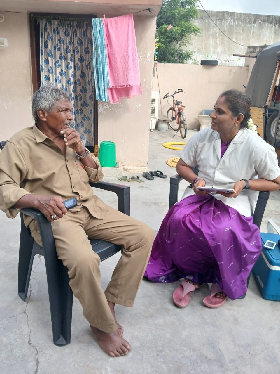 Healthcare worker interviewing elderly man during home visit