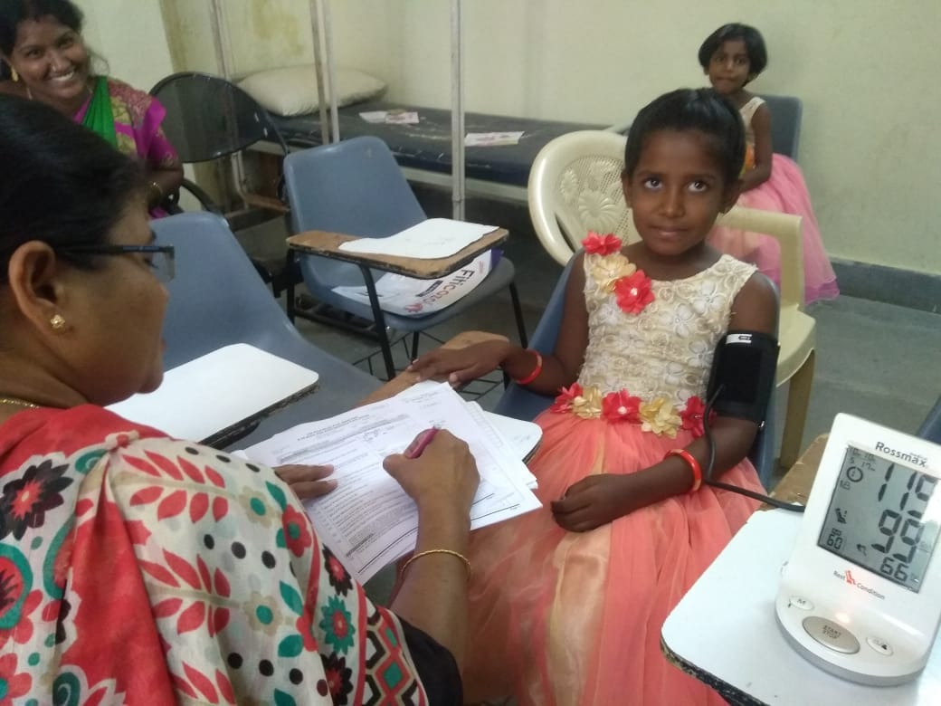 A health worker diagnosing a toddler girl