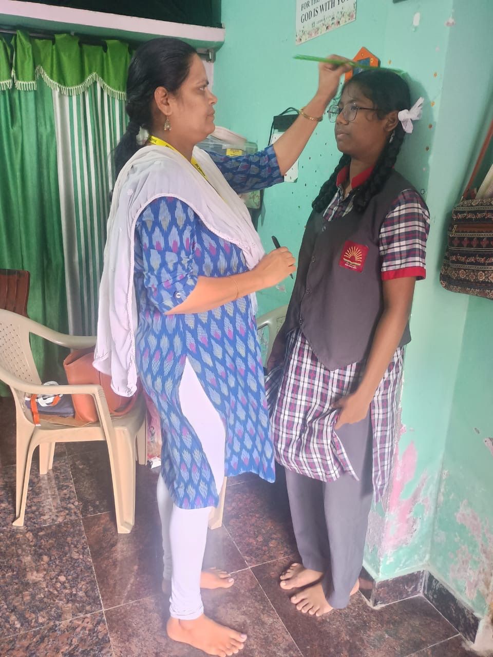 Healthcare worker measuring height of student for nutritional assessment