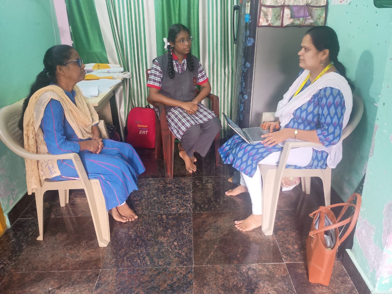 A health worker conducting a survey with a mother and her school-going daughter