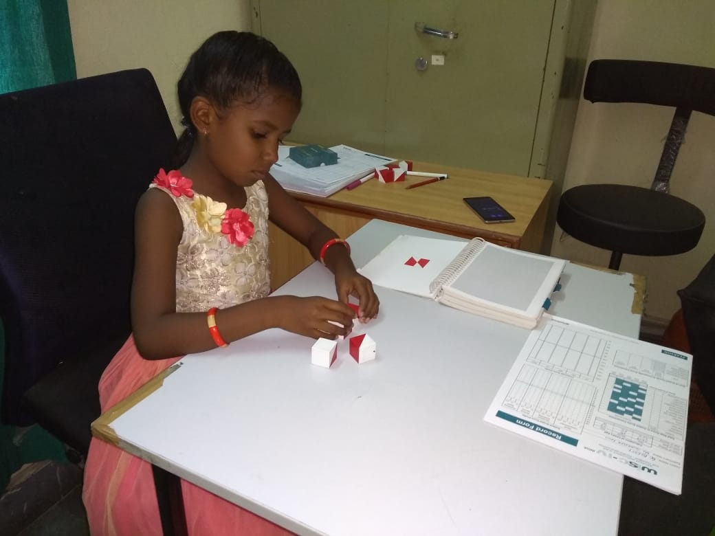 A toddler girl playing with an assembling block