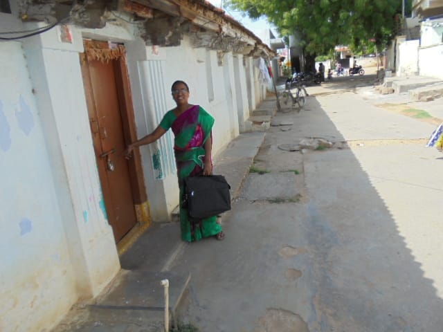 A health worker outside a house conducting a survey