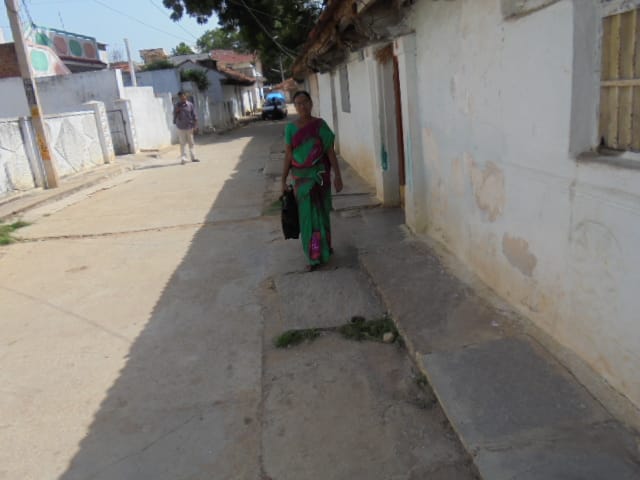 A health worker outside a house conducting a survey