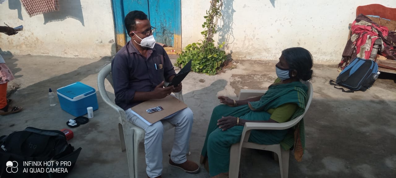 A health worker diagnosing an old lady