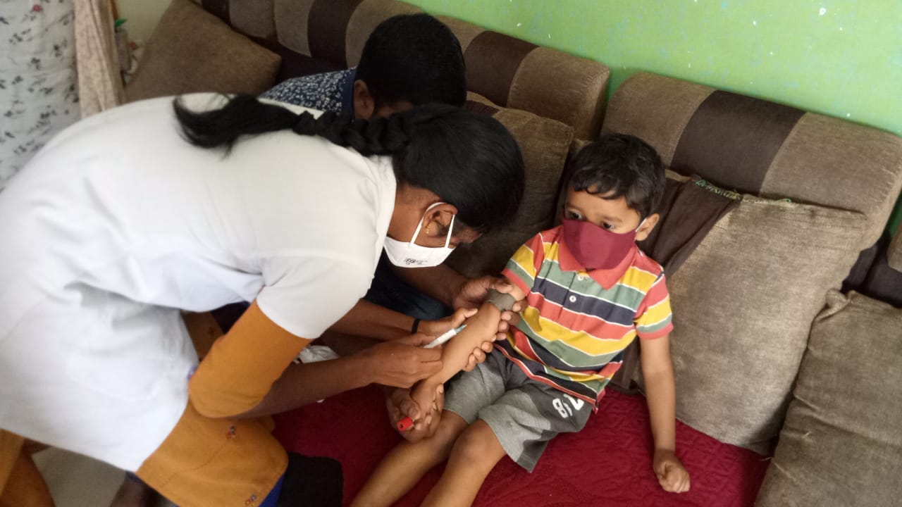 A health worker giving an injection to a toddler boy