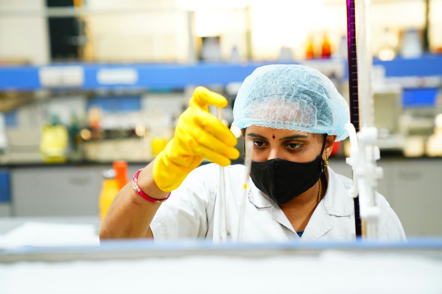 Laboratory technician carefully handling a test sample while conducting scientific analysis in a clinical lab