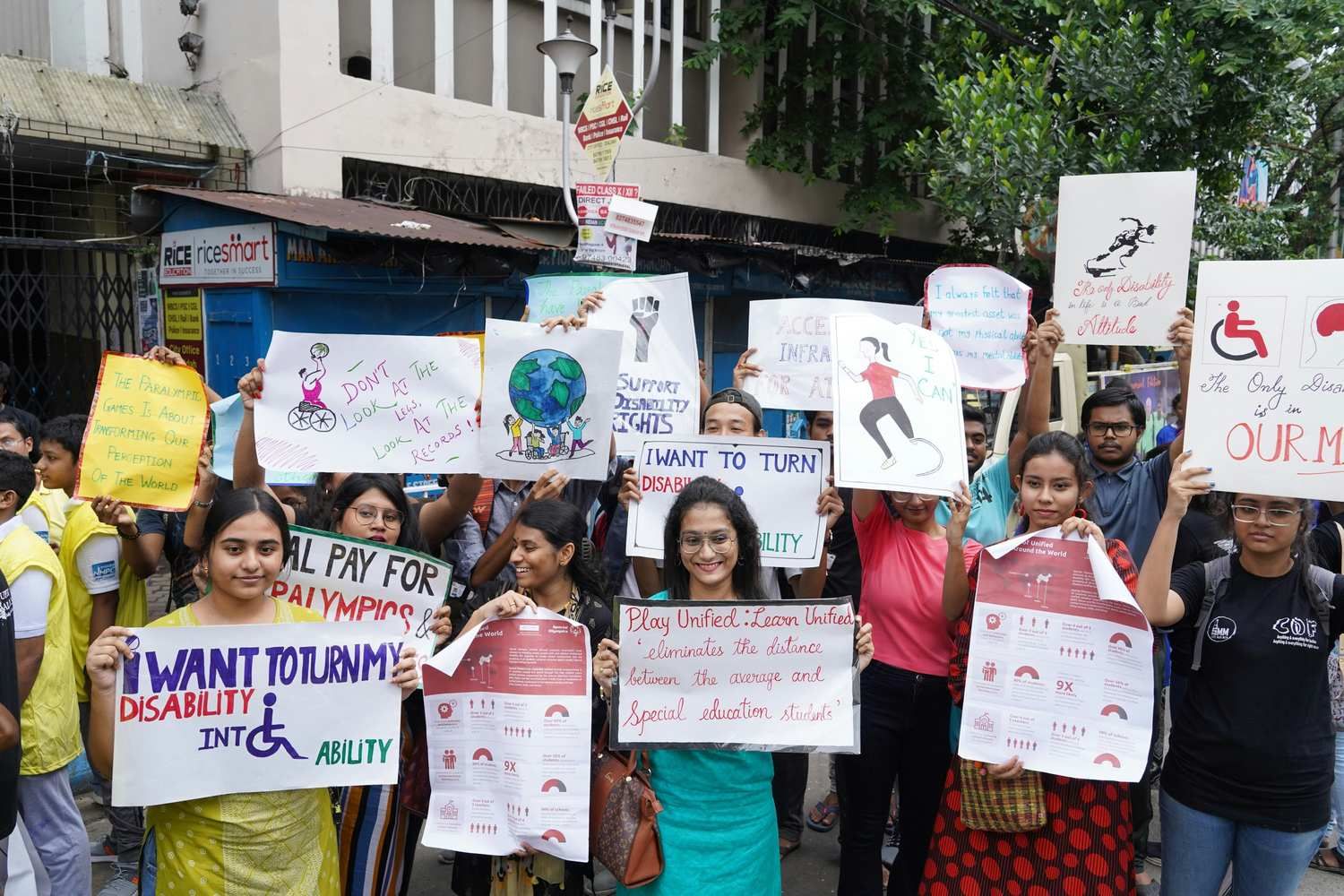 Group of people participating in an awareness rally, holding placards promoting disability inclusion and equal opportunities