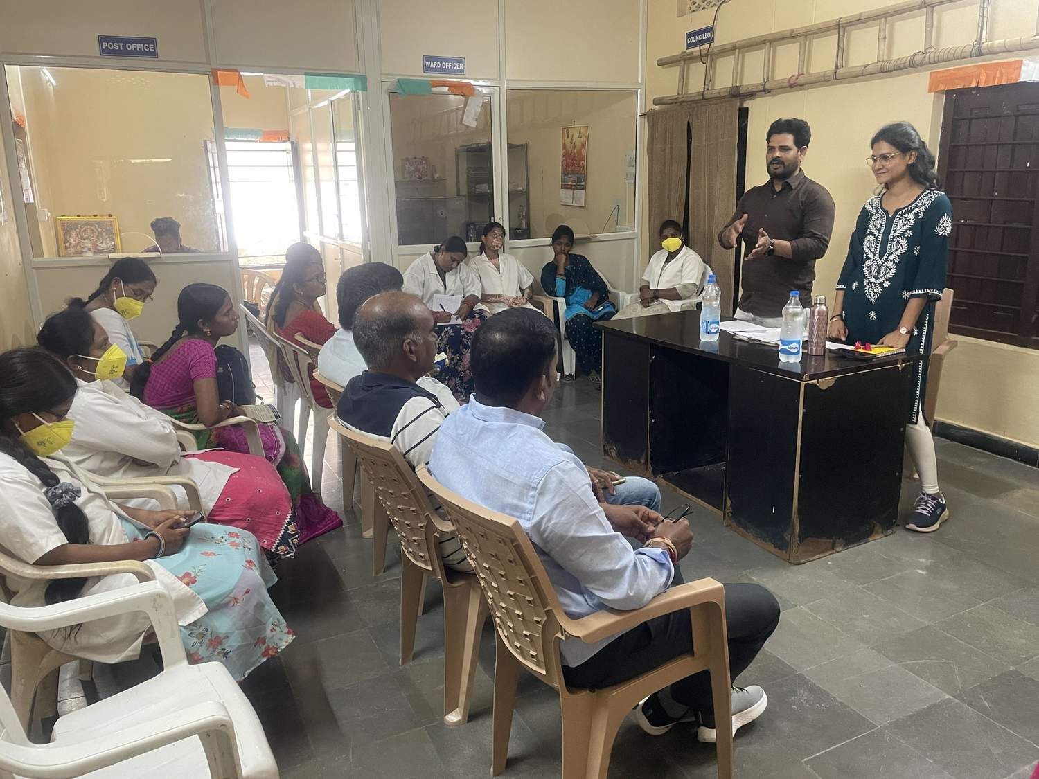 Healthcare professionals conducting a training session and discussion with community health workers in a clinic setting