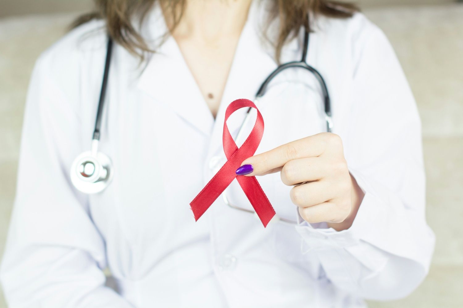 Doctor holding red ribbon symbol for HIV AIDS awareness