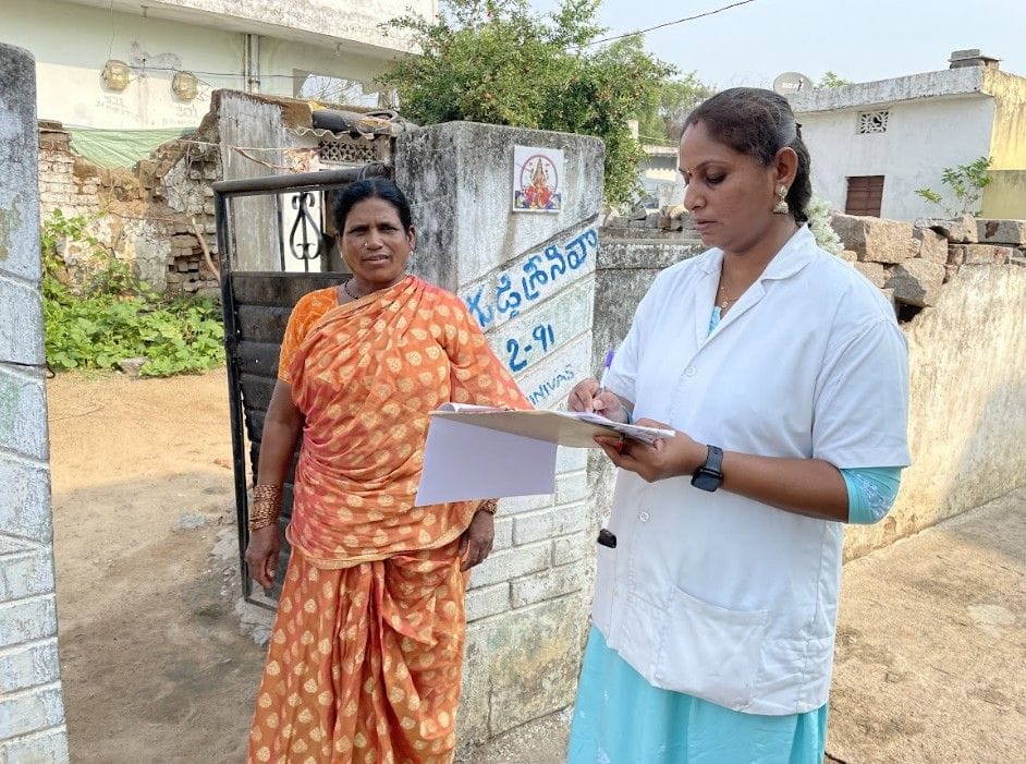 Healthcare worker recording information during door-to-door survey with community member