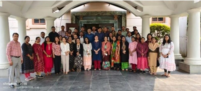 Group photo of healthcare professionals and staff gathered at an institutional building during a workshop or program