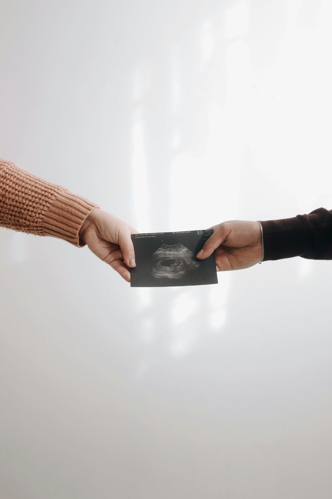 Hands holding and sharing ultrasound scan image