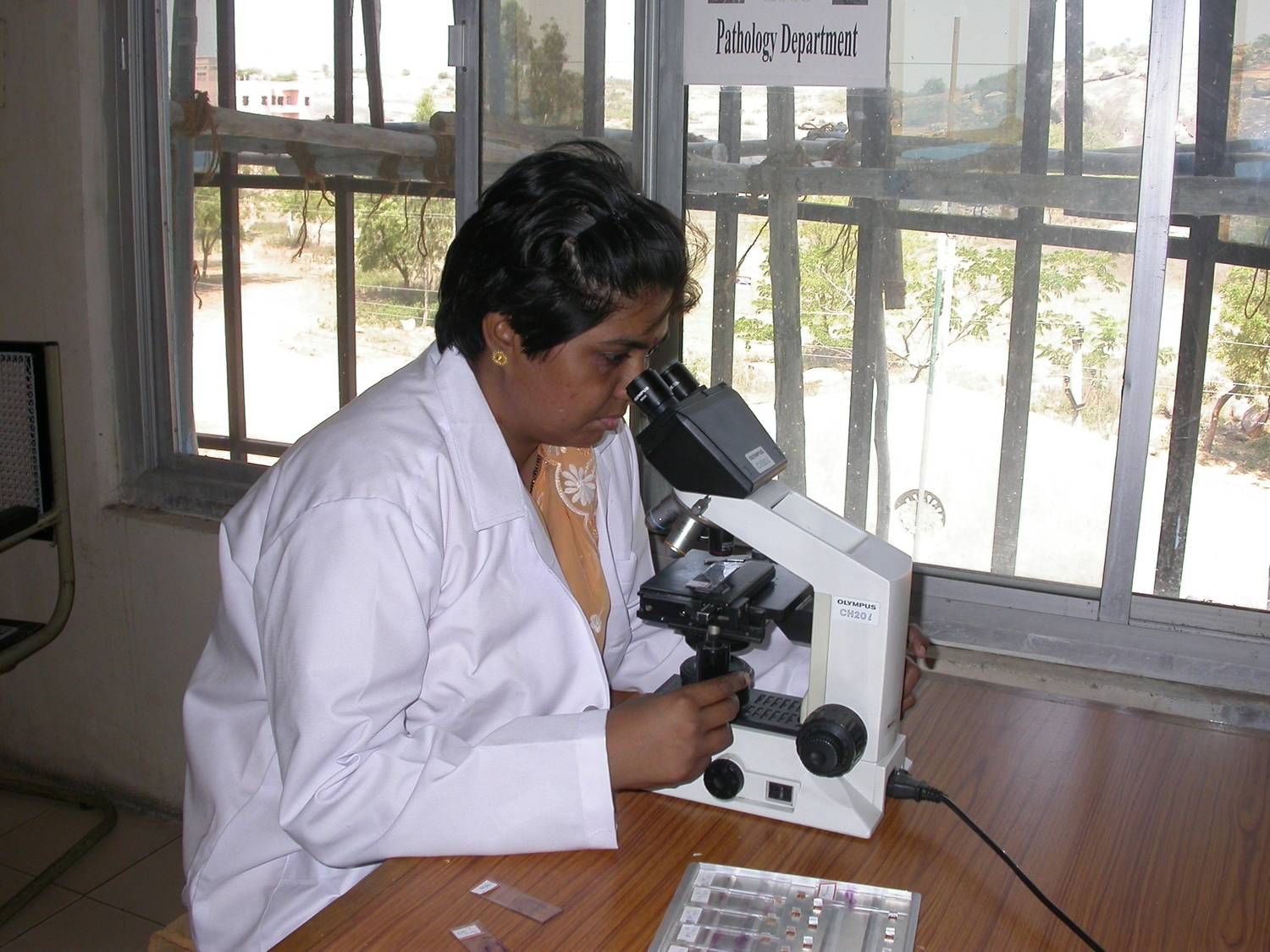 Pathologist examining samples under a microscope in a laboratory setting