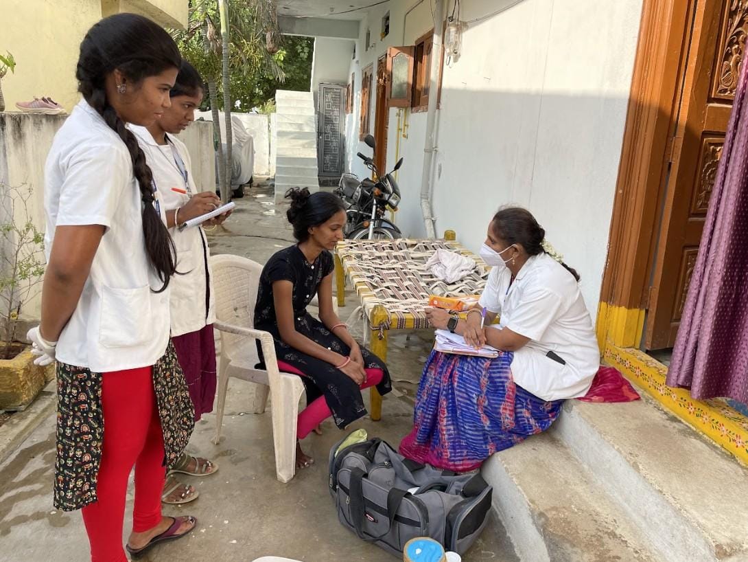 Healthcare workers conducting a home visit consultation, recording patient details and providing medical guidance in a community setting