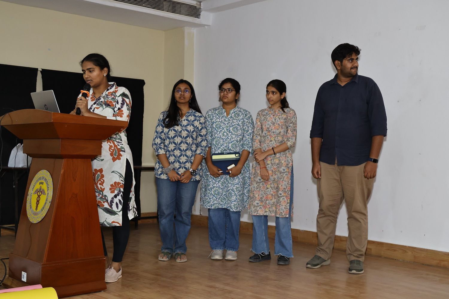 Student presenting with a microphone at a podium